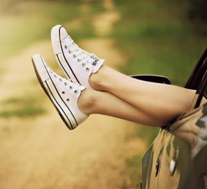 Legs sticking out of car window (loosely crossed with casual shoes)