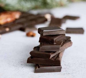 Dark chocolate pieces stacked on a light coloured surface